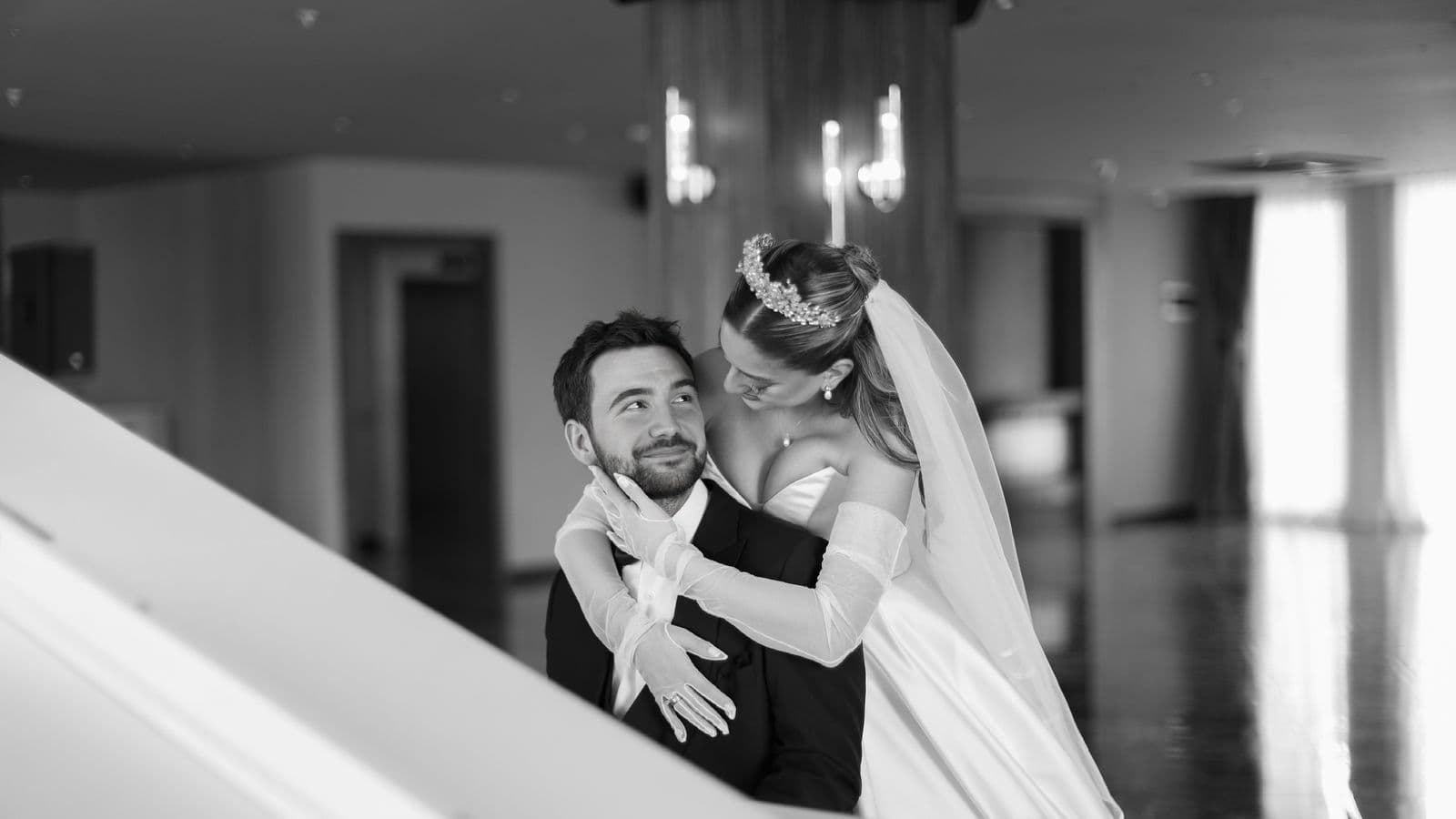 The couple laughing together beneath the bride's veil